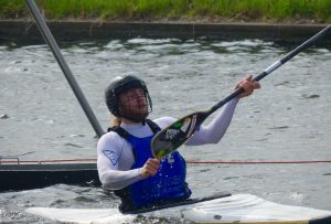 Ein Kanupolospieler, der das Paddel nach oben hält